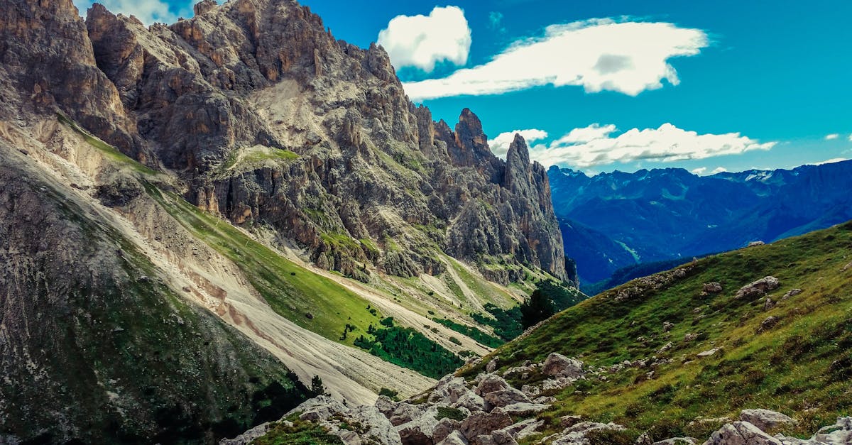 Breathtaking view of the Dolomite mountains with vibrant blue sky and lush greenery.